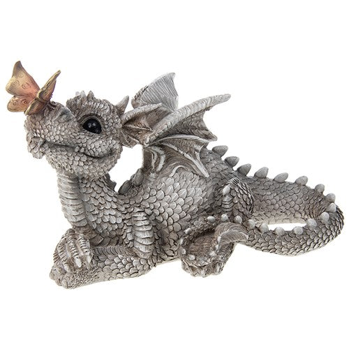 Happy cute grey dragon lying down with a butterfly on his nose